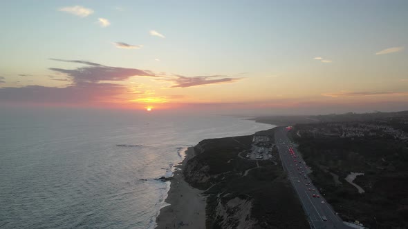 Aerial 4k view of a sunset illuminating stunning beach front luxury homes.