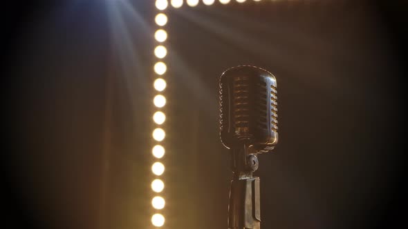 Microphone on Stage with Smoke Anding Light Behind It. Professional Concert Vintage Glare Microphone