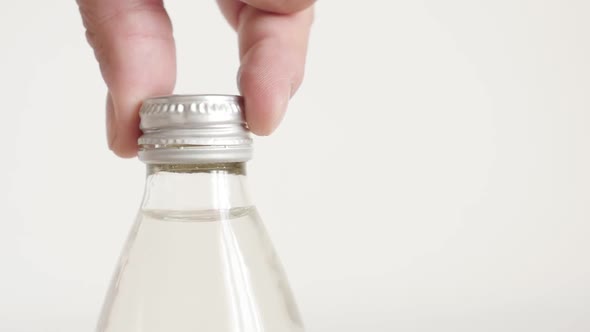 Slow motion opening glass bottle with fingers close-up footage