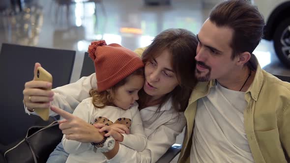 Young Family Doing a Selfie with Smart Phone While Waiting for Airplane