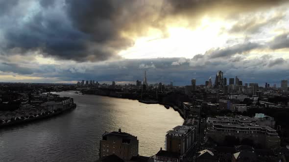 Aerial view of London skyline under dramatic stormy dark clouds at sunset