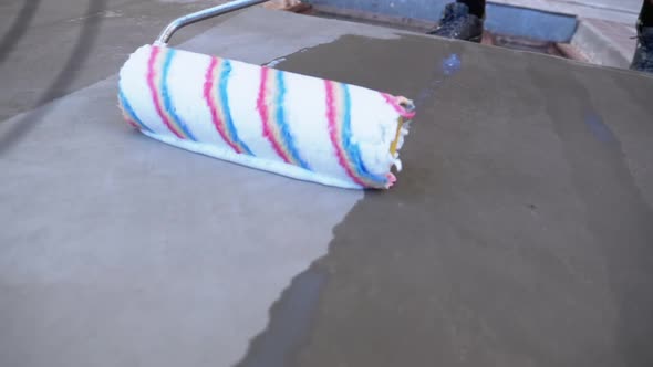 Industrial Climber Primers the Wall of Building with a Roller. Slow Motion