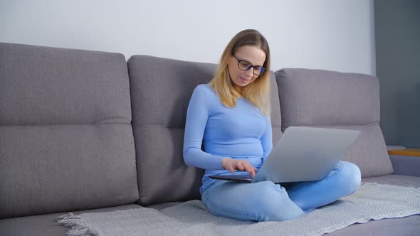 Freelancer writer working on modern notebook computer on couch at home in 4k