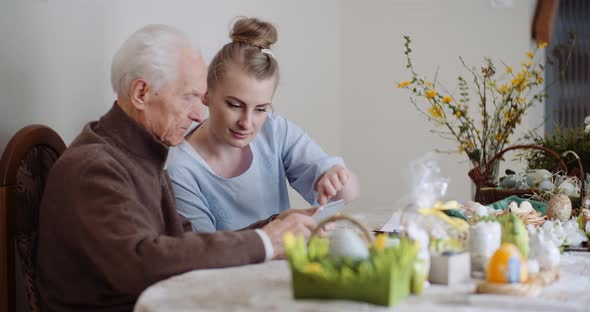 Granddaughter with Grandfather Using Digital Tablet