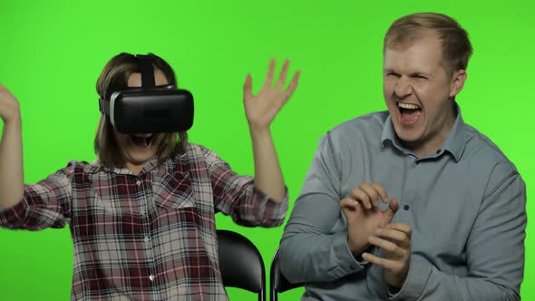 Man and Woman Using VR Headset Helmet To Play Game. Watching Virtual Reality 3D Video. Chroma Key