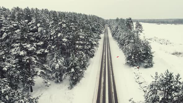 Snowy Winter Countryside Landscape with Forest and Small Road Aerial View