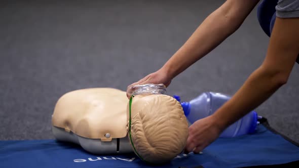 Teaching cardiopulmonary resuscitation with dummy. Instructor demonstrating CPR on mannequin 