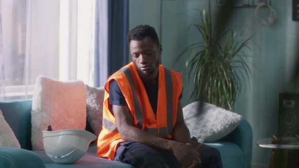 Tired Black Engineer Standing Up From Sofa