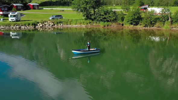 Woman on the Boat Catches a Fish on Spinning in Norway.