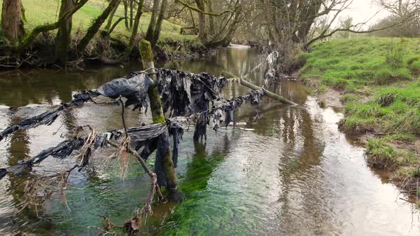 Plastic pollution on a river in Cumbria from farming practices such as big baling silage which invol