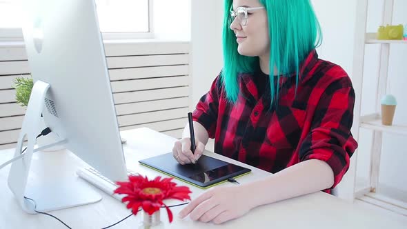 Young Graphic Designer with Color Hair Working on Computer Using Tablet