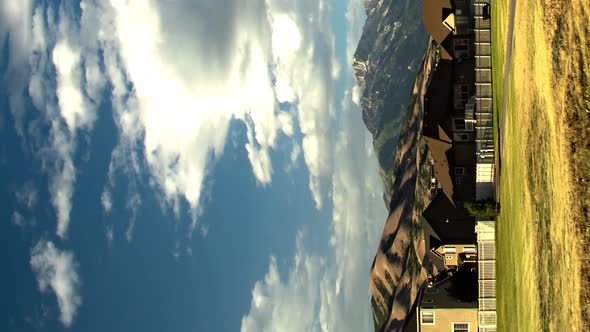 Vertical time lapse of a housing area in a valley and foothills and mountains in the background zoom