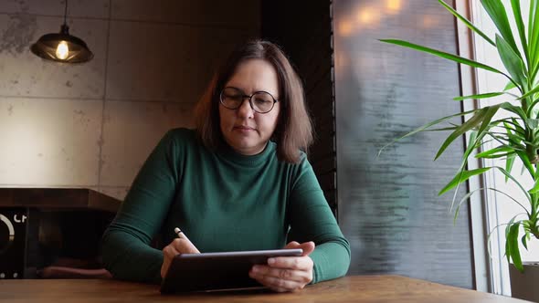 Pretty Woman Sitting in Cafe and Working