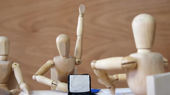 Wooden figurines having meeting in conference room in office on wooden background