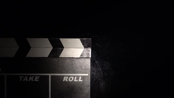 Person Uses Movie Clapper Board on Black Close Up