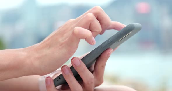 Woman using mobile phone in city