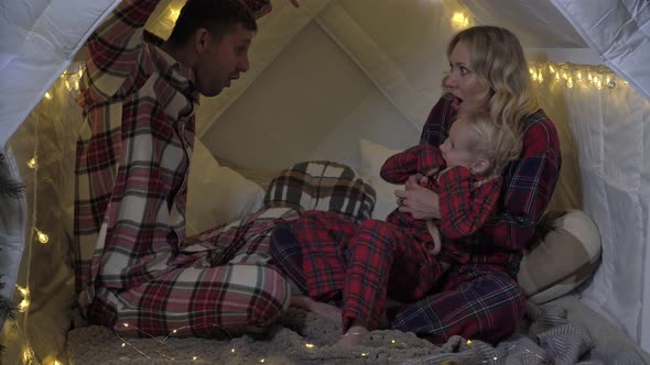 Happy Family in Pajamas Celebrates Christmas