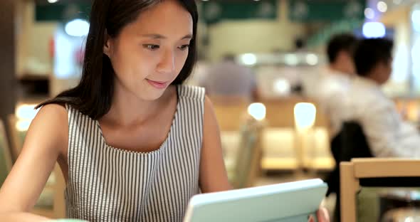 Young Woman making order on tablet inside restaurant