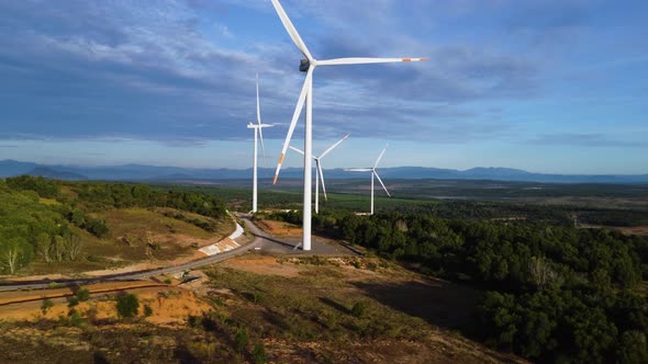 Four Giant Wind Turbines With Propellers Slowly Spinning In The Wind Background With Blue Sky In Sou