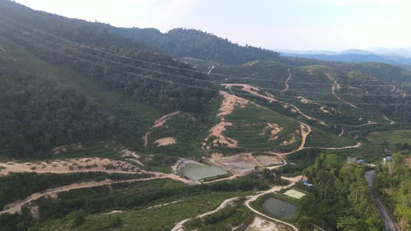 Drone flying towards Fish Pond, Farms and Hills in Kuala Klawang
