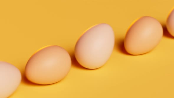 Rolling eggs on a yellow pastel background. Happy Easter. Spring celebration.