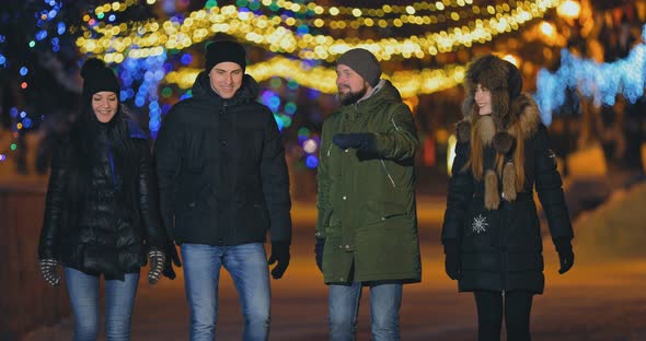 Happy Company of Friends Walks the Night City in the Winter