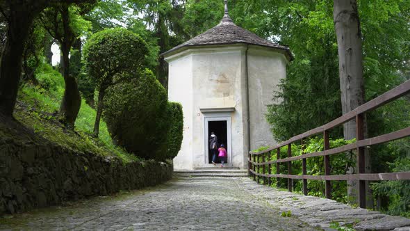 A mother and her little daughter carrying a teddy bear visiting the sacred mountain of Varallo chris