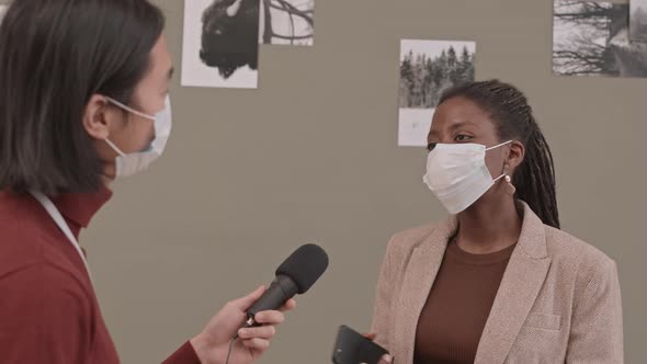 Female Photographer Giving Interview in Art Gallery