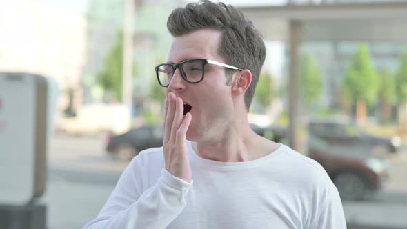 Portrait of Sleepy Young Man Yawning Outdoor