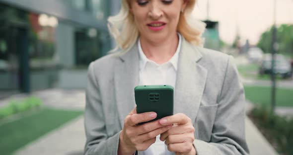 Closeup View of Female Hands Using Smartphone at Street.