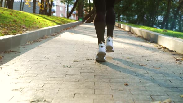 Feet of Woman Jogging in Autumn Park