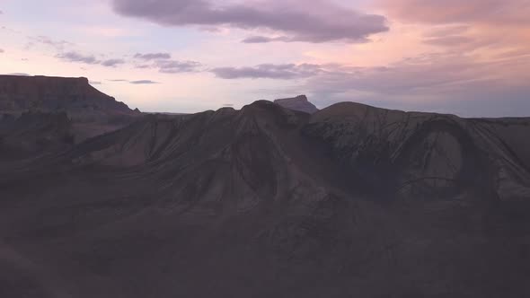 Aerial view flying up and over sand dunes at dusk