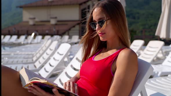 Rich Lady is Reading Book Near Pool in Resort Hotel in Mountain Area Vacation and Relax