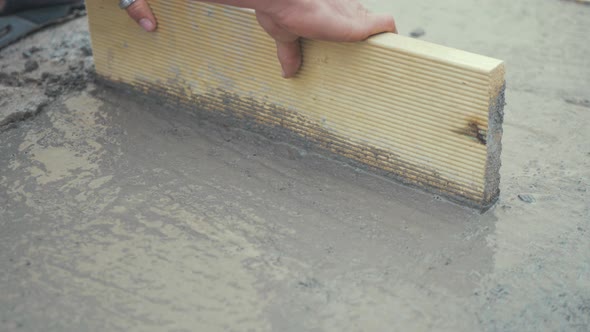 Working flattening freshly poured cement CLOSE UP