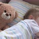 Happy Baby Sleeping in Crib with His Favorite Teddy Bear Toy - VideoHive Item for Sale