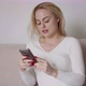 Young Woman Using Smartphone on Sofa - VideoHive Item for Sale