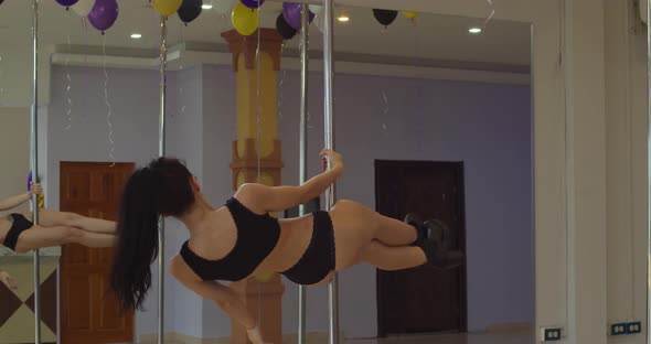 Pole dancing moves from a young hispanic girl in a dance studio