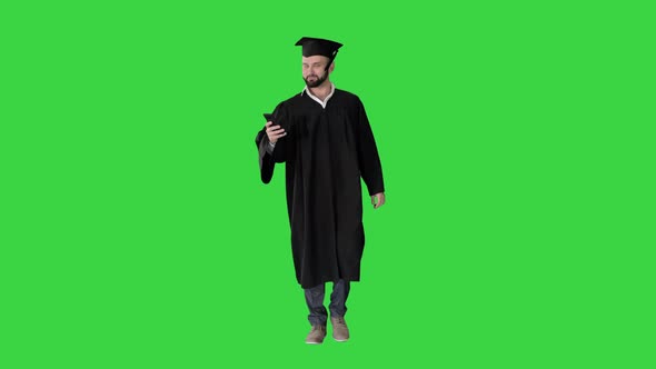 Graduate Student Walking and Texting Message on the Phone on a Green Screen, Chroma Key.