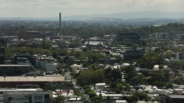 Traffic moving between residential areas and industrial zones from high angle above suburban area.