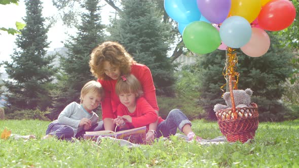 Mom and Daughter Reading a Book in the Park