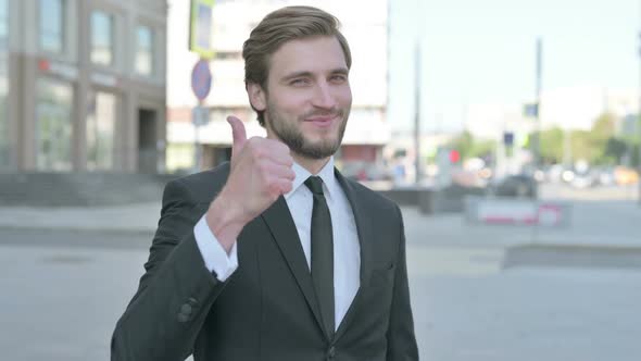 Thumbs Up By Businessman Standing Outdoor