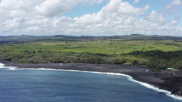 Descending close-up aerial shot of a brand new black sand beach on the Big Island of Hawaii. 4K