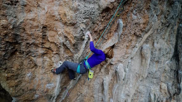 Strong Girl Rock Climber Climbs Rock Tufa on Overhanging Crag