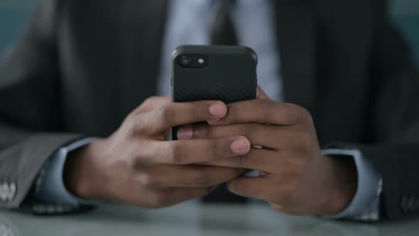 Close up of Hands of African Businessman using Smartphone