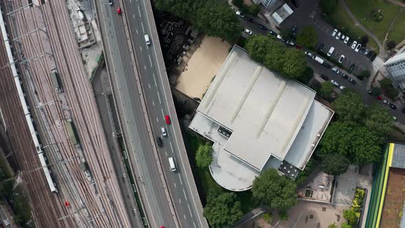 Top down drone shot of busy highway and train line near residential area