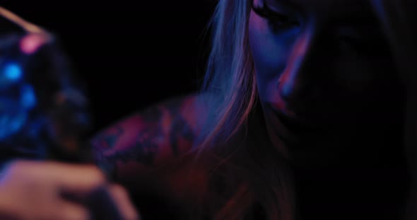 Close up of a young female tattoo master tattooing in her studio. BMPCC 4K