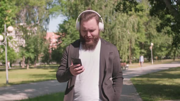 Man Listening to Music and Walking in Park