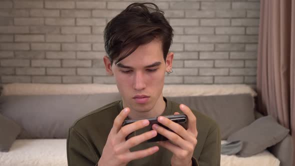 Teen Using Smart Phone Plays Mobile Games App at Home