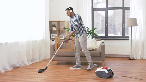 Man in Headphones with Vacuum Cleaner at Home 61