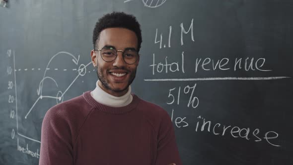 Man Posing by Chalkboard